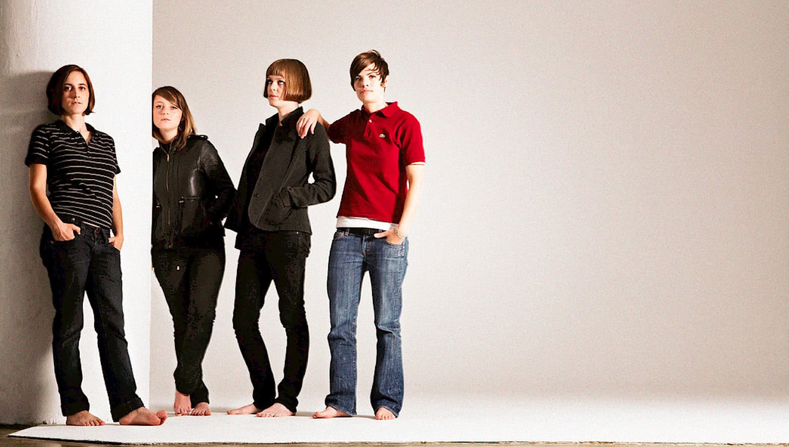 Girls standing against white wall, casual fashion, modern clothing, teenage friends, relaxed pose, barefoot, minimalistic background, youth style, contemporary look, isolated setting, fashion statement, social media style, urban casual, stylish teens, gallery shot, 5 girls, diverse outfits, youthful energy, lifestyle, modern family, popular culture, cultural trends, lifestyle photography, pastdaily archive, news, music, history, sound archive relevance.