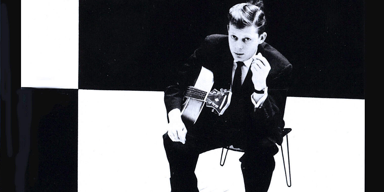 Boy playing acoustic guitar black and white photo, vintage news, historical music archive, classic musician portrait, nostalgia music history collection.