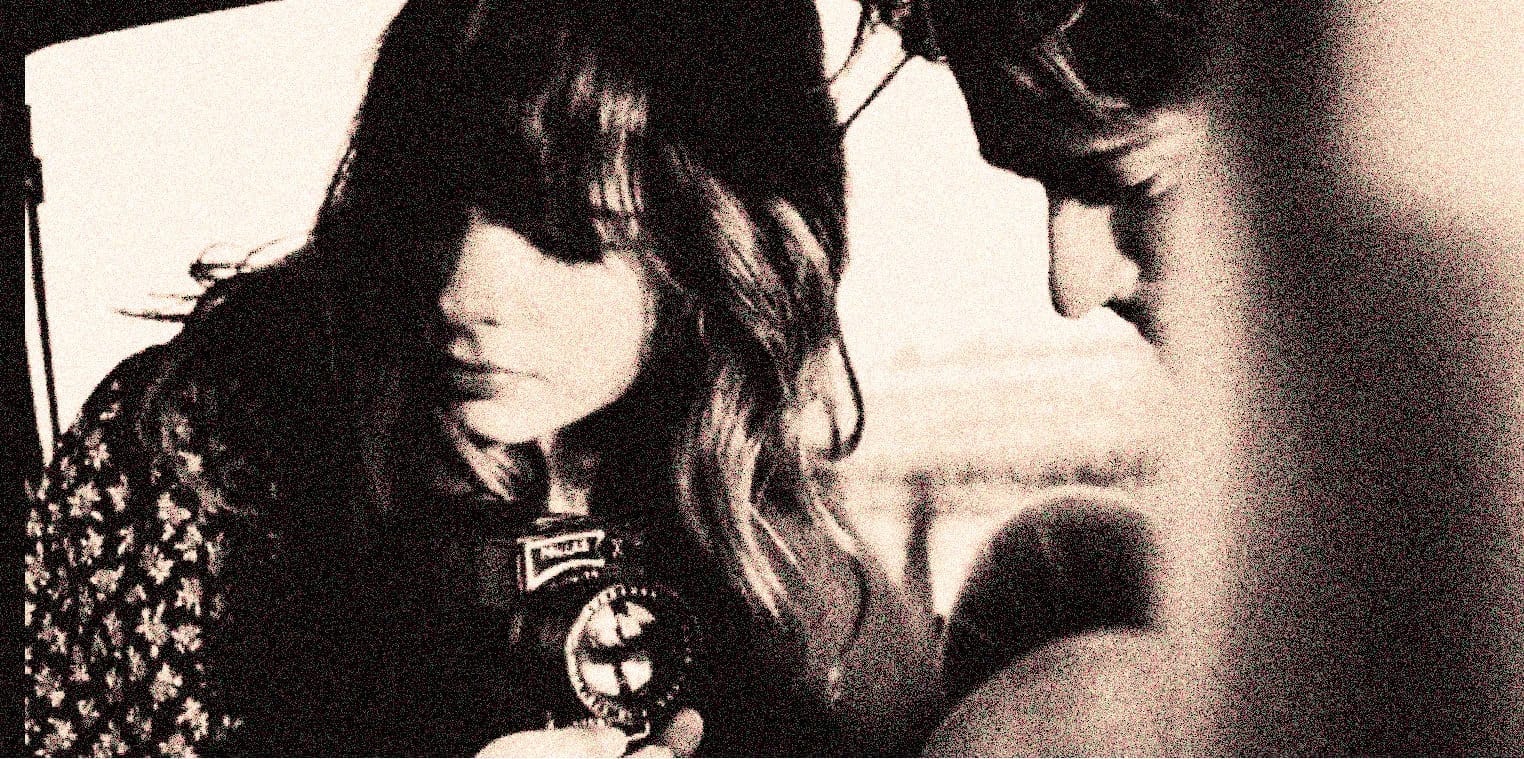 Shallow focus of two young women, one holding a vintage camera, black and white portrait, nostalgic photo of film photography, vintage media, 1960s style, old-fashioned camera, candid moment, retro photography theme.