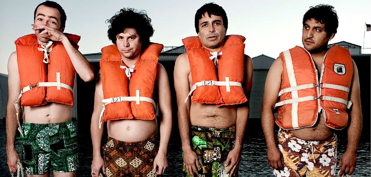 Life of Brian movie scene with men wearing life jackets on the beach, parody comedy, popular culture, British humor.