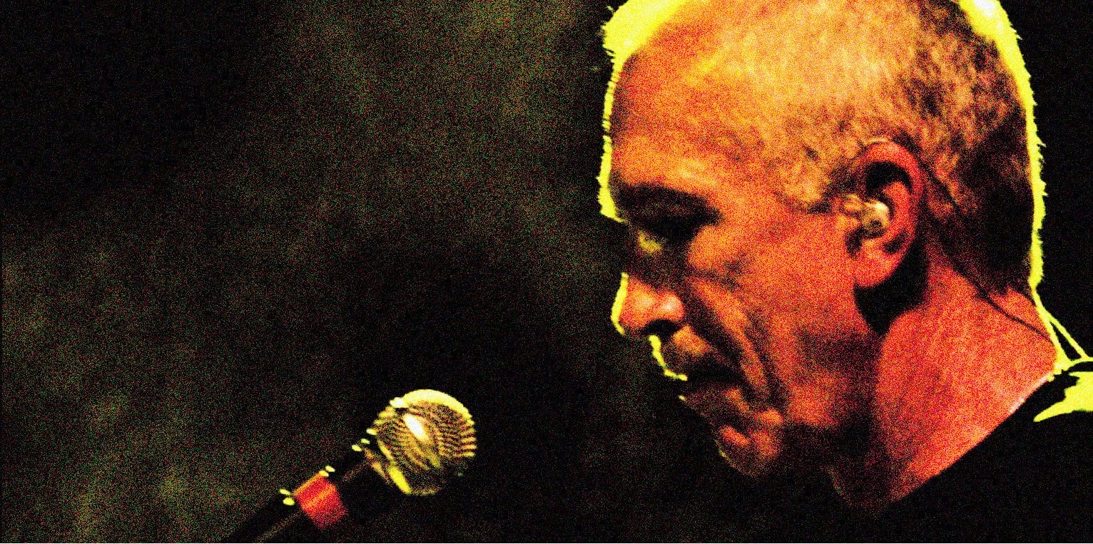 A vintage-style close-up photo of a musician singing into a microphone, highlighting the history of music recordings and sound archives on Past Daily.
