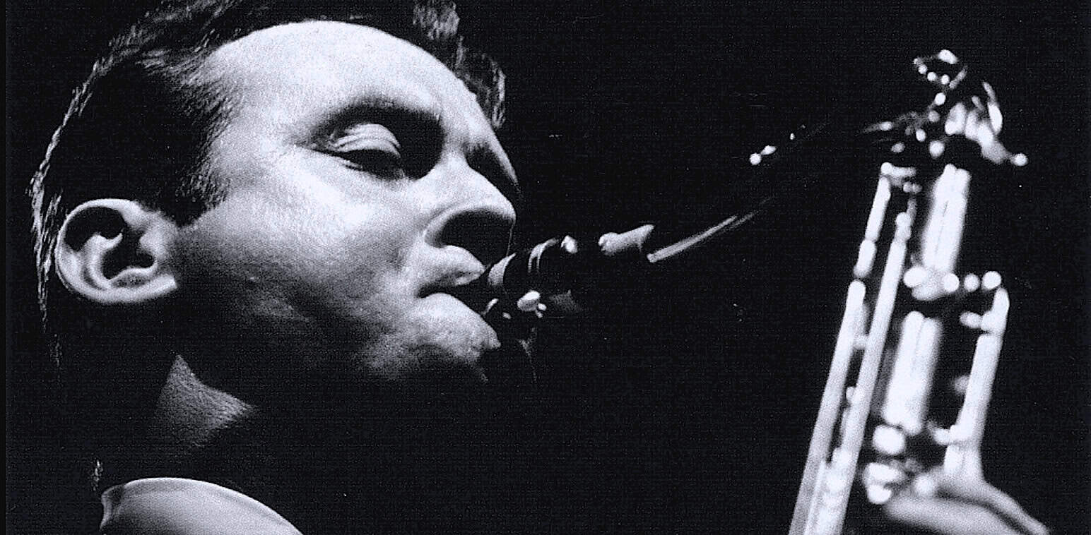 Elegant black and white close-up photo of a jazz musician playing a saxophone, emphasizing musical heritage, classic jazz, and sound archive themes.