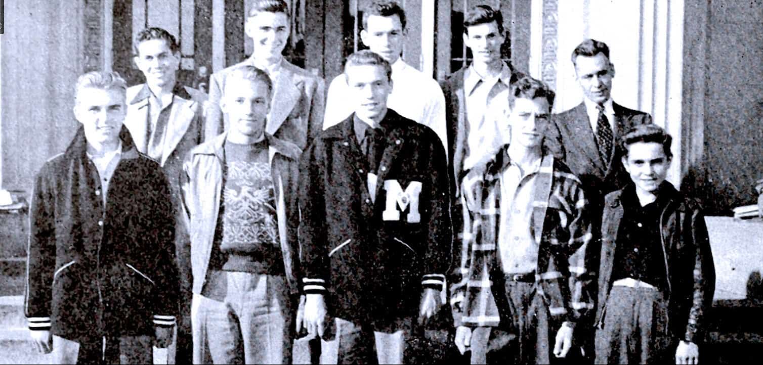 Vintage black and white photo of a school group in the 1950s, featuring students and teachers outside a building, showcasing mid-century educational history and youth culture.