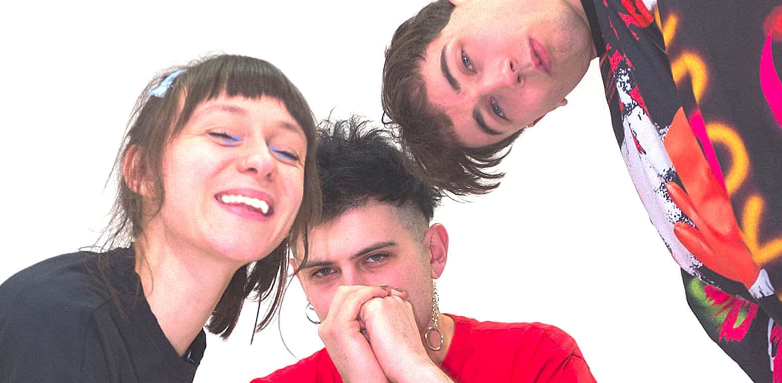 Vibrant music band members smiling and posing together, showcasing a lively atmosphere in the music industry, ideal for news, history, and music sound archives.