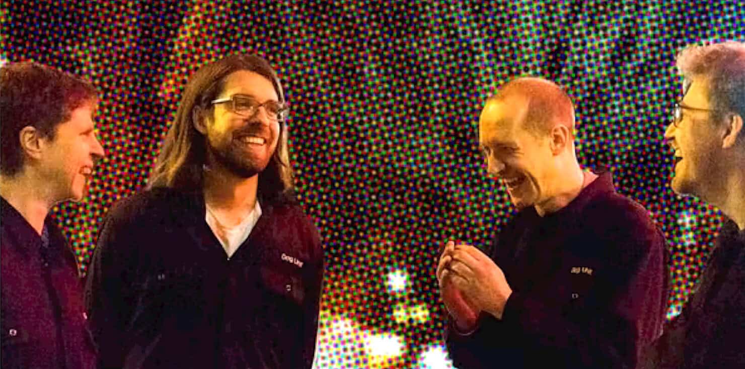 People having a joyful conversation during a music event with colorful background, celebrating news, history, and music archives.