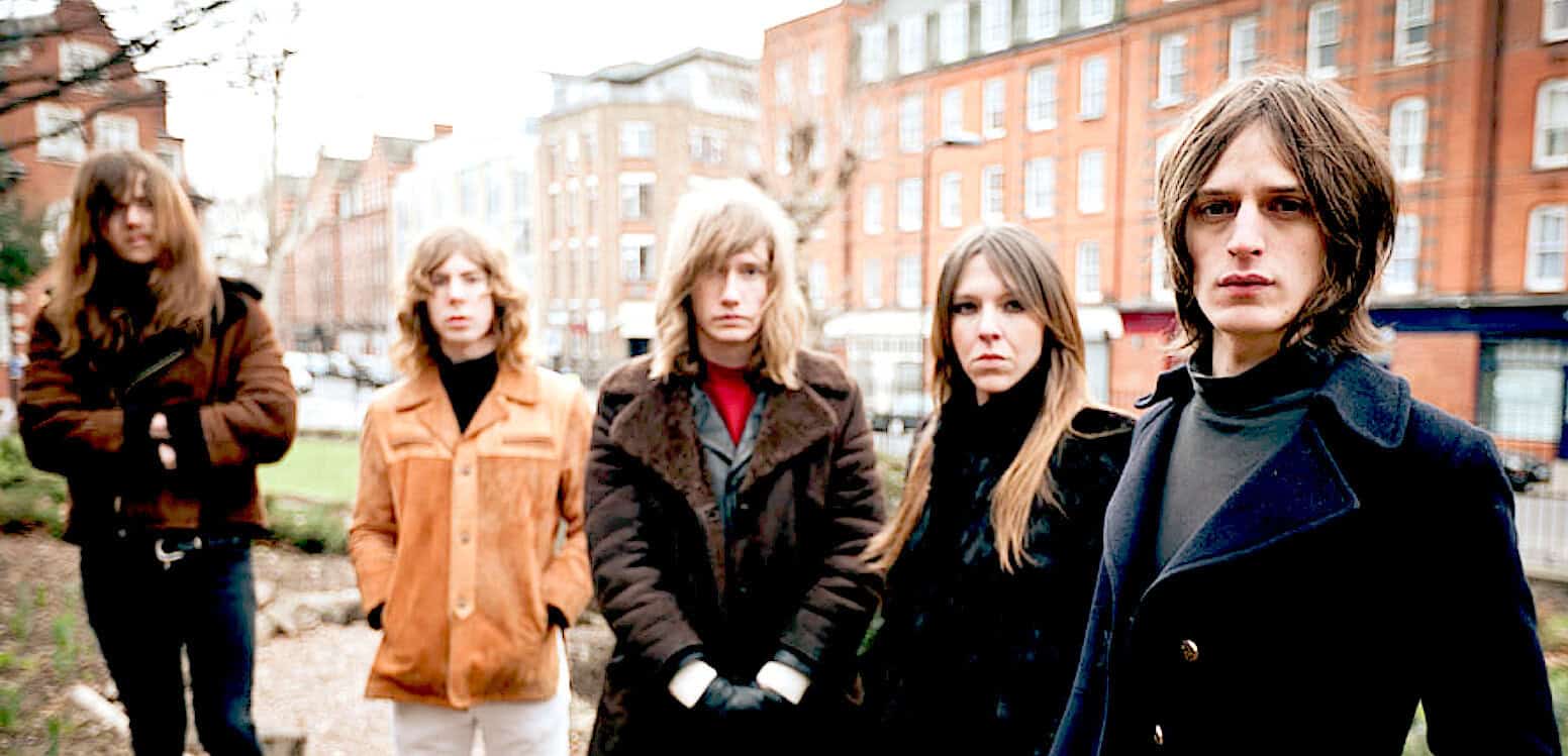 Band of young women posing outdoors in urban setting, capturing music, history, and pop culture themes for a sound archive.