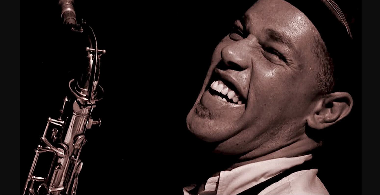 Saxophonist performing jazz music, passionate soulful singing, live music concert, jazz musician, music archive, vintage sound recording, music history, classic jazz performance, Past Daily news and music collection, historical sound archive.