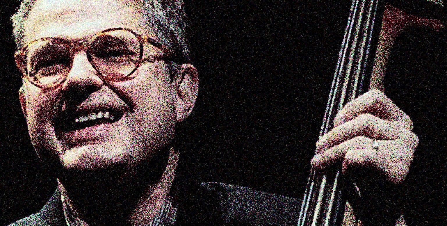 Vintage jazz musician playing double bass, captured in a nostalgic, high-contrast black and white photo, emphasizing music history and classic jazz sound archive themes.