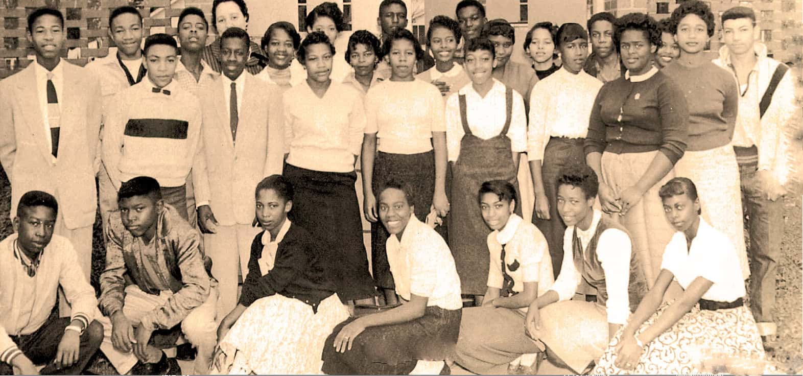 Vintage black and white photograph of school children and teachers posing outdoors, capturing historical moments in education and community life.
