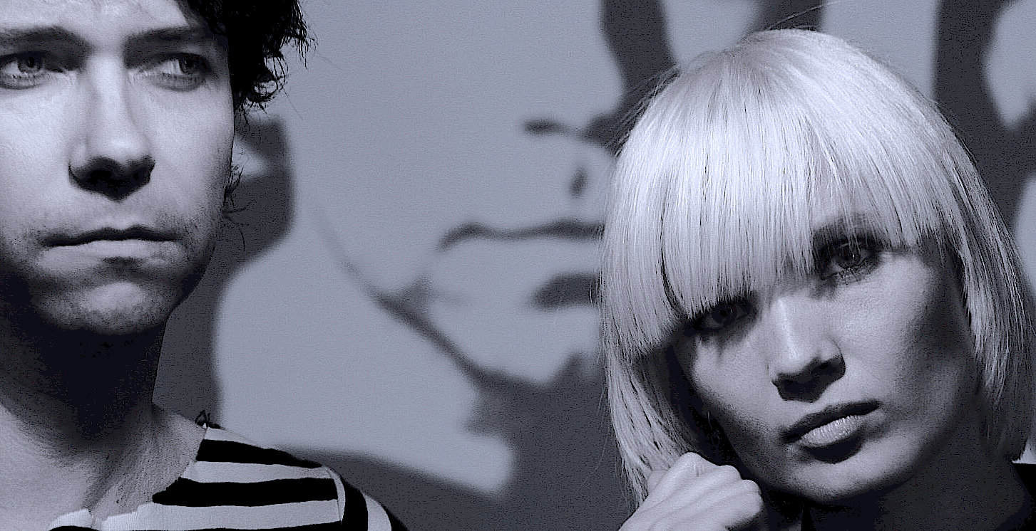 Archive photo of a young man and woman with striking hairstyles, emphasizing vintage news, music, and history sound archives from Past Daily.