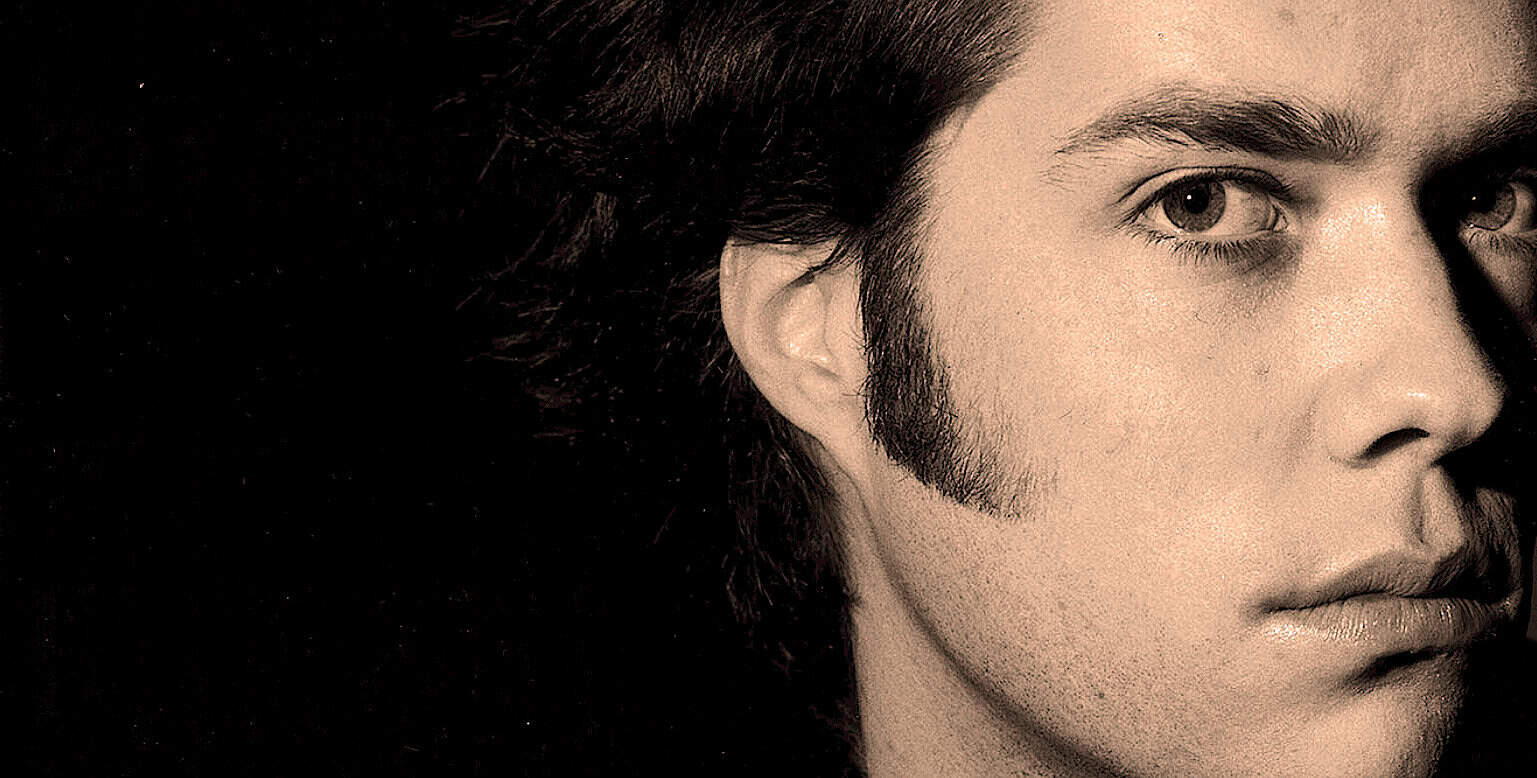 1960s rock musician portrait, vintage style, male artist with long hair and sideburns, nostalgic music era, iconic music history image, classic artist photography, retro music scene, nostalgic music archive image, historic musician photo, music royalty-free image.