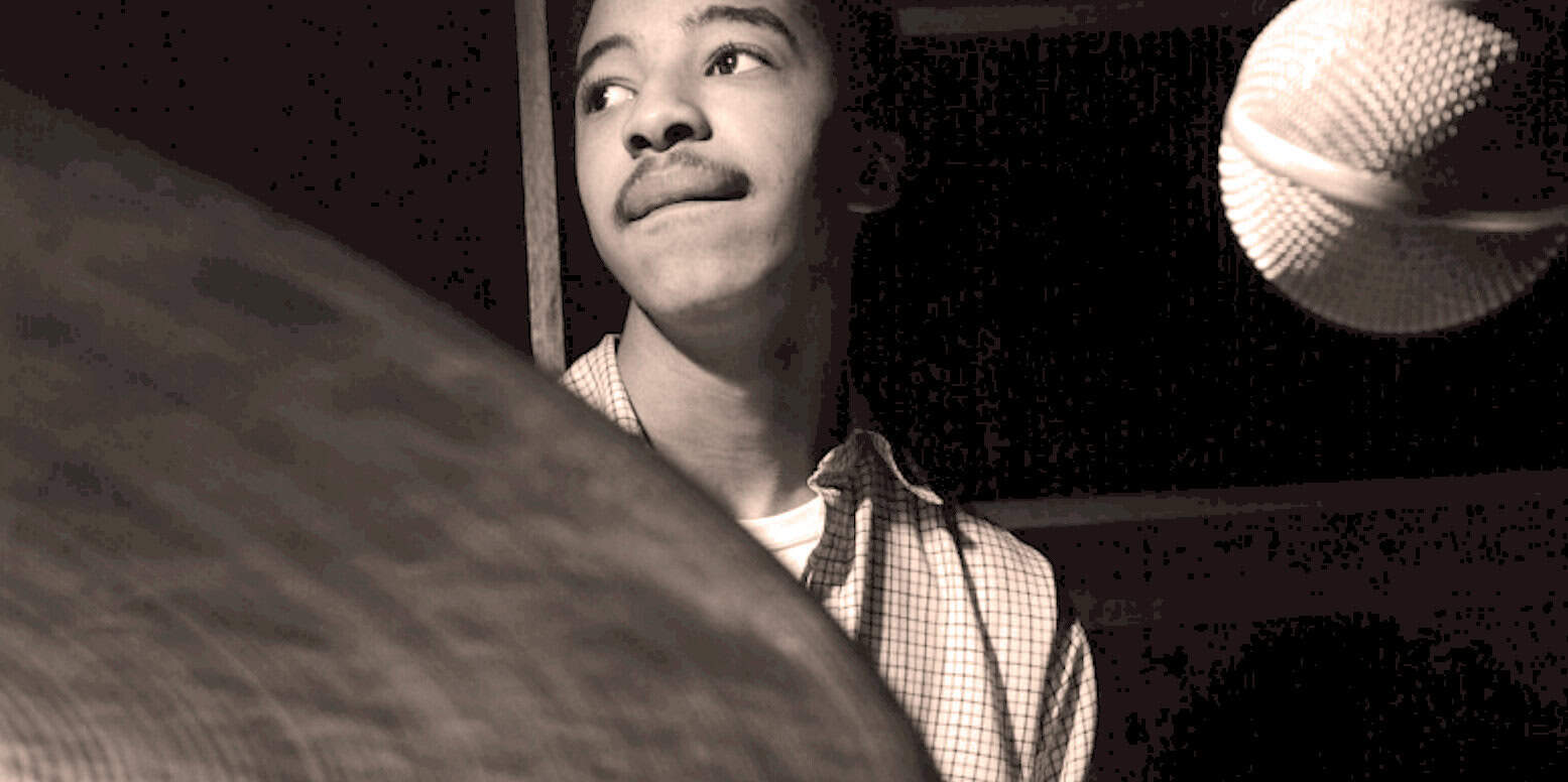 Young man recording in a sound studio, capturing news, music, and historical audio for Past Daily archive.