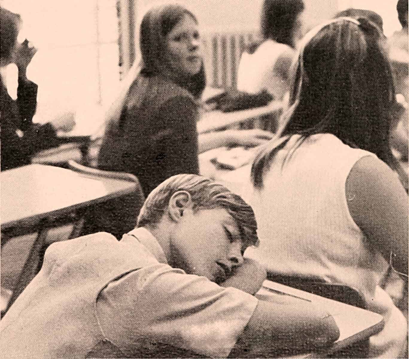 Student sleeping on desk in classroom, black and white photo, nostalgic school scene, past daily archive, education history and learning environment.