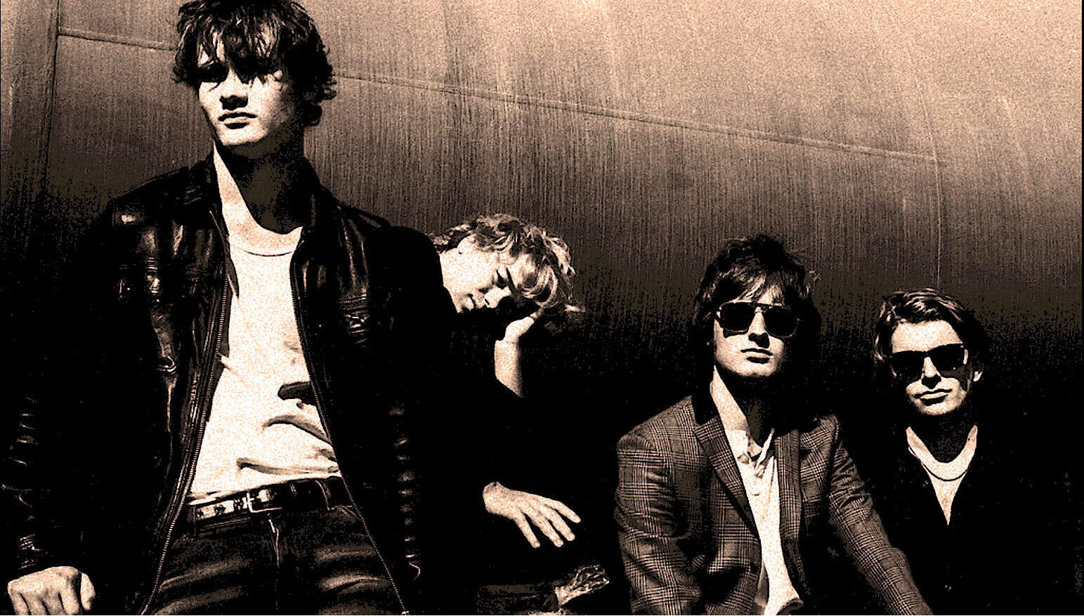Vintage rock band photo, four musicians with sunglasses and 1960s style clothing, highlighting classic music history and musical legends.
