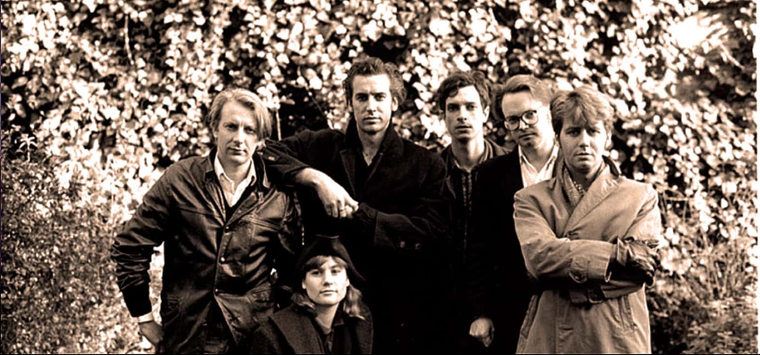 Vintage black and white photo of a band outdoors, capturing classic rock musicians, referencing history, music, and news archives.