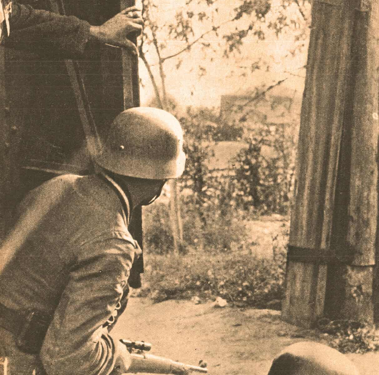 Old black and white photo of two soldiers, one sitting and one standing, watching a distant scene, symbolizing wartime news and history preservation.