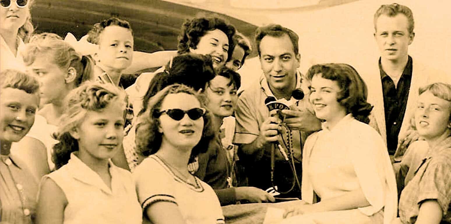 Historical news event with a diverse group of children and adults gathered outdoors, capturing a nostalgic moment reflected in vintage sepia tone, emphasizing archives of past news, history, and American culture.