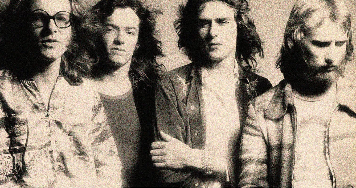 Vintage black-and-white photo of a rock band with long hair and casual attire, emphasizing music history and classic band imagery for nostalgic music archive SEO.