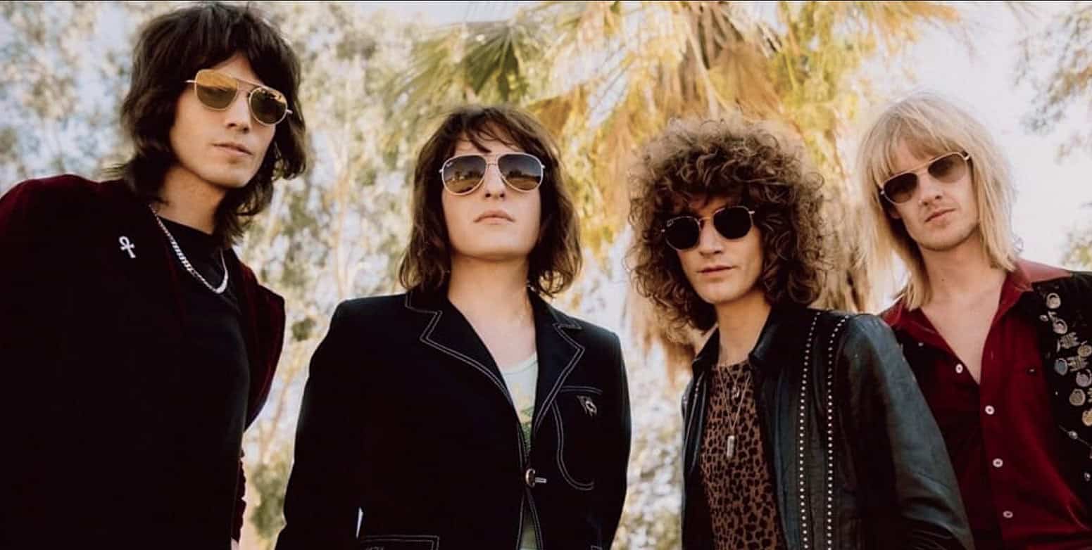 Retro rock band members wearing sunglasses outdoors for music and history archive images.