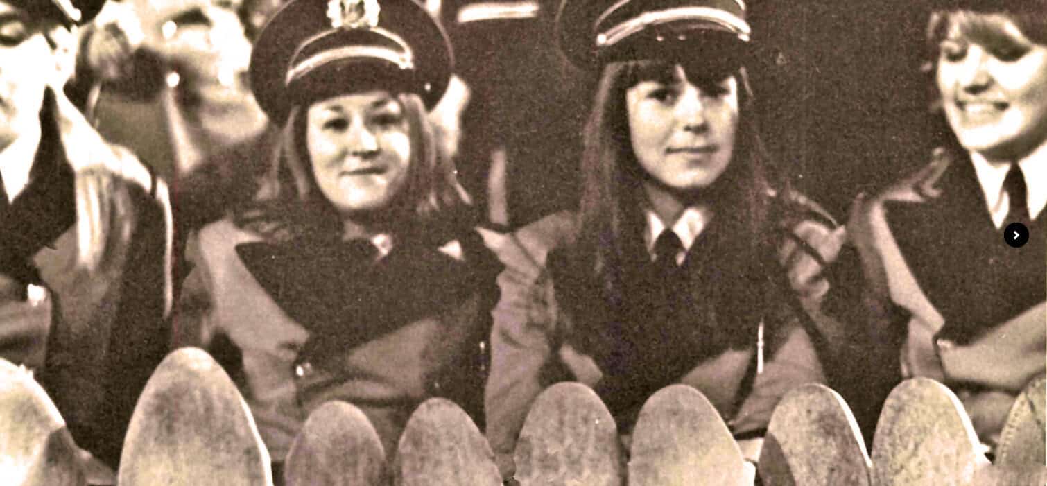 Women police officers in vintage uniforms smiling in a historical black-and-white photo, emphasizing police history, law enforcement, and women in uniform.