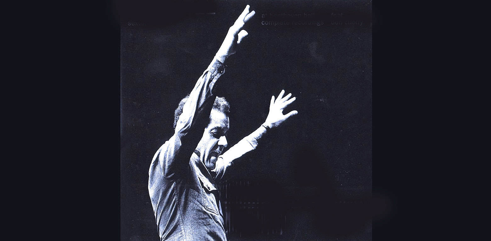 Vintage black and white image of a male singer passionately performing with arms raised, capturing the essence of classic music and historic live performances from the sound archive of pastdaily.com.