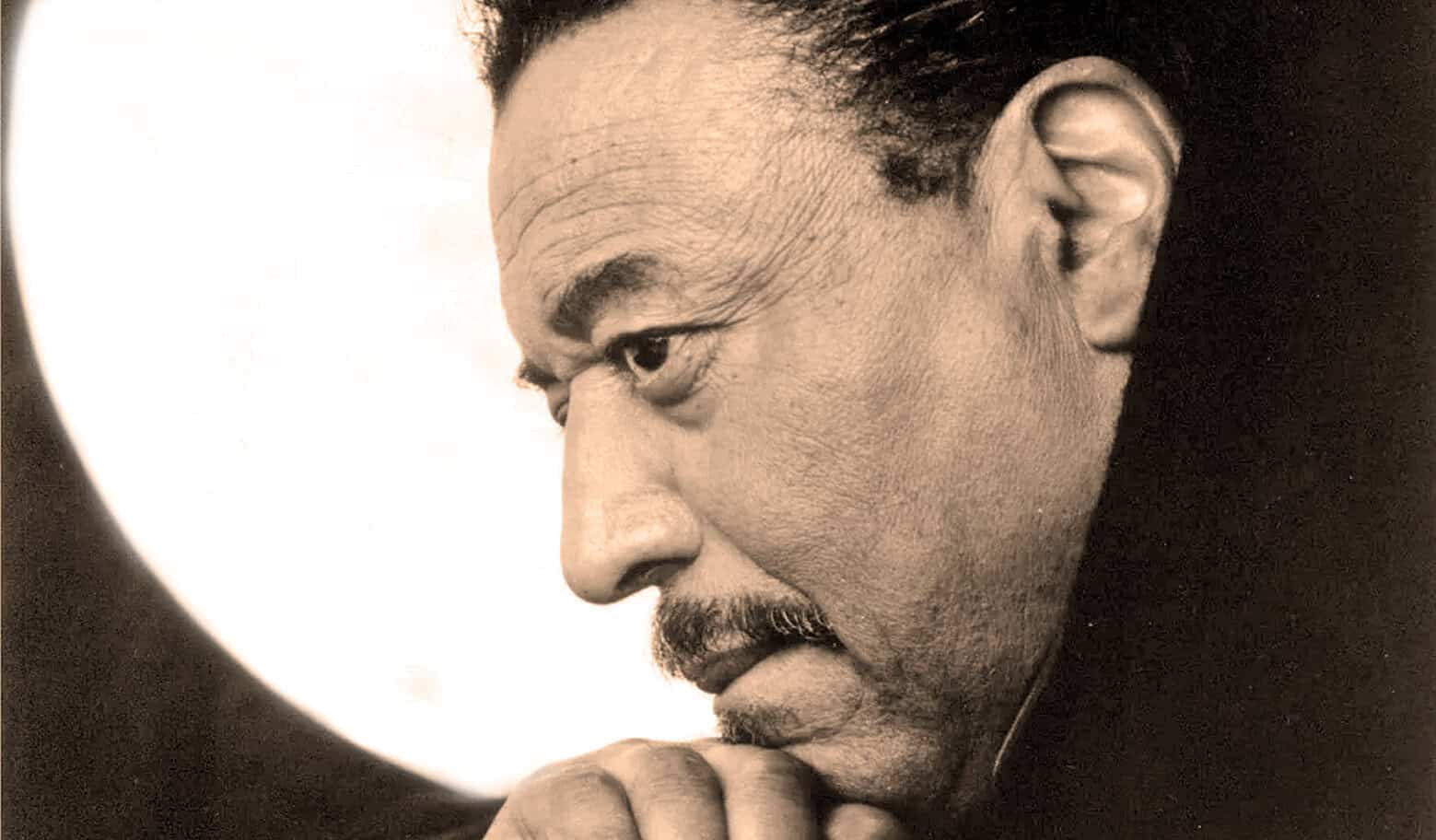 Thoughtful man in profile with hand on chin, black and white photo emphasizing reflective mood and introspection.