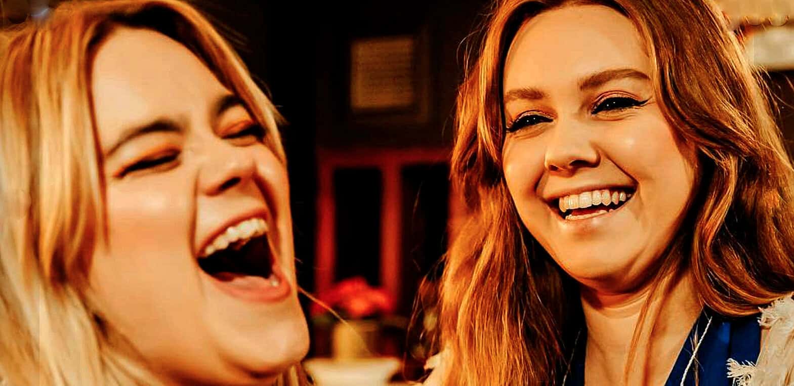 Funny women laughing, joyful friendship, happiness, friendship, red hair, cheerful, social gathering, positive emotions, warm ambiance, authentic moment, entertainment, lively atmosphere, happiness sharing, best friends, joyful companionship.