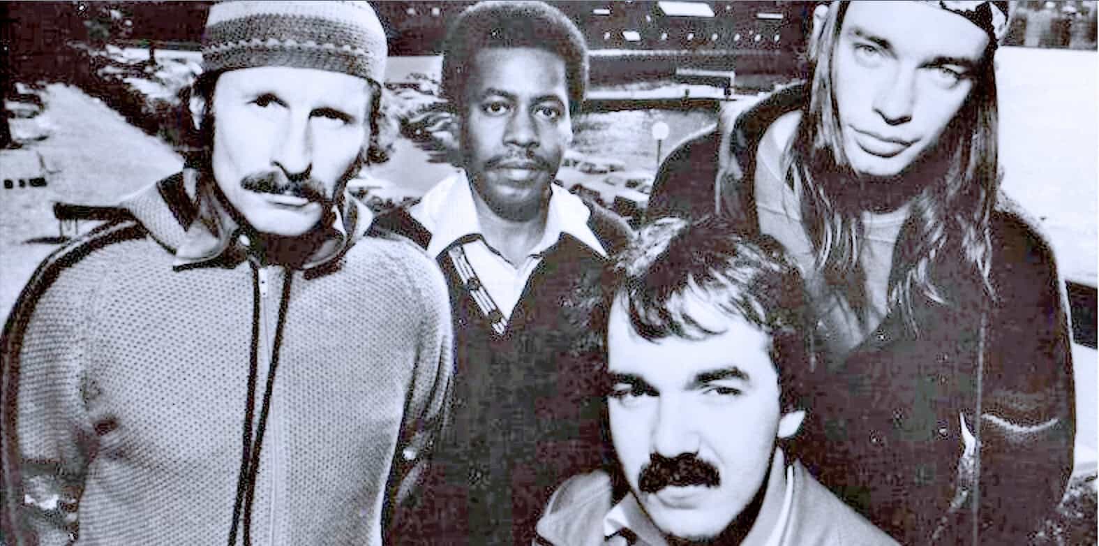 Vintage black and white photo of The Beatles, iconic rock band, outdoors in winter, showcasing members John Lennon, Paul McCartney, George Harrison, and Ringo Starr, captured in early 1960s style.