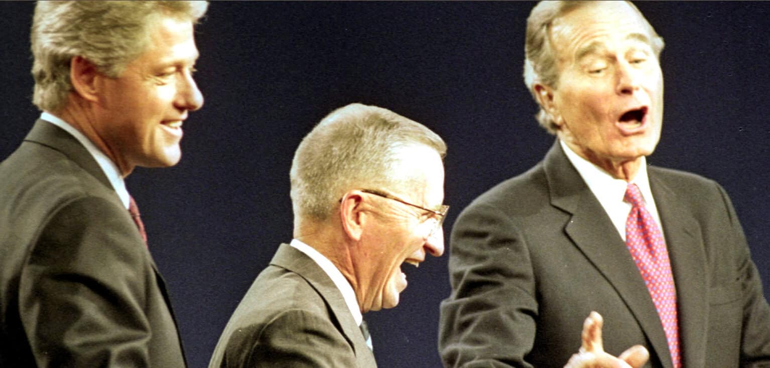 Photo of three men laughing and talking during a political debate or discussion, emphasizing news, history, and political commentary.