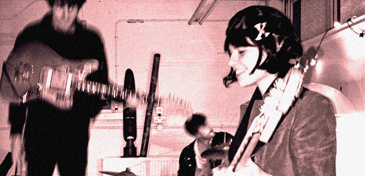 Vintage live music session featuring musicians with guitars and drums, capturing 1960s rock and roll history, music archive photo.