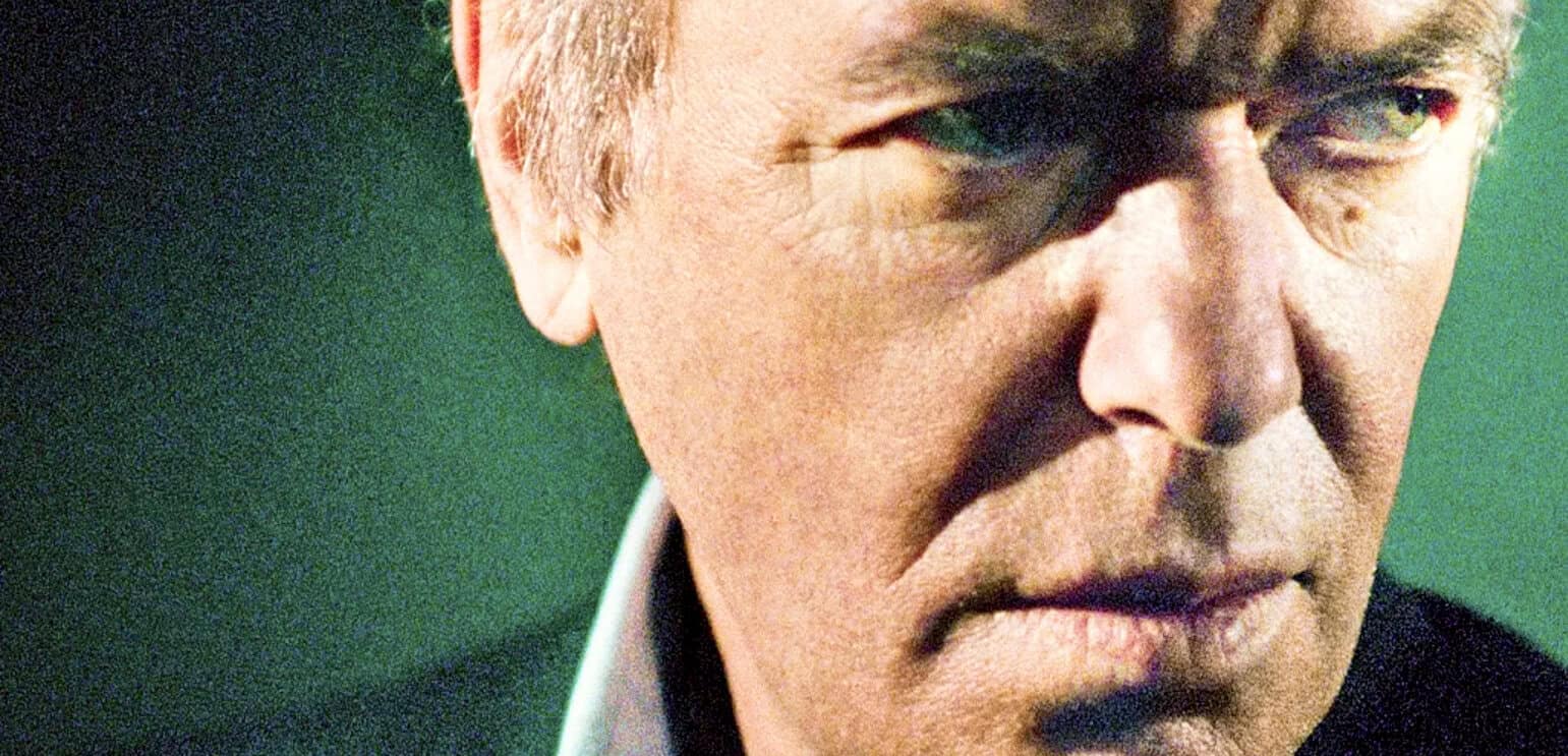 Close-up of a man's serious face, emphasizing his eye, representing historical news, classic music, and vintage sound archives.