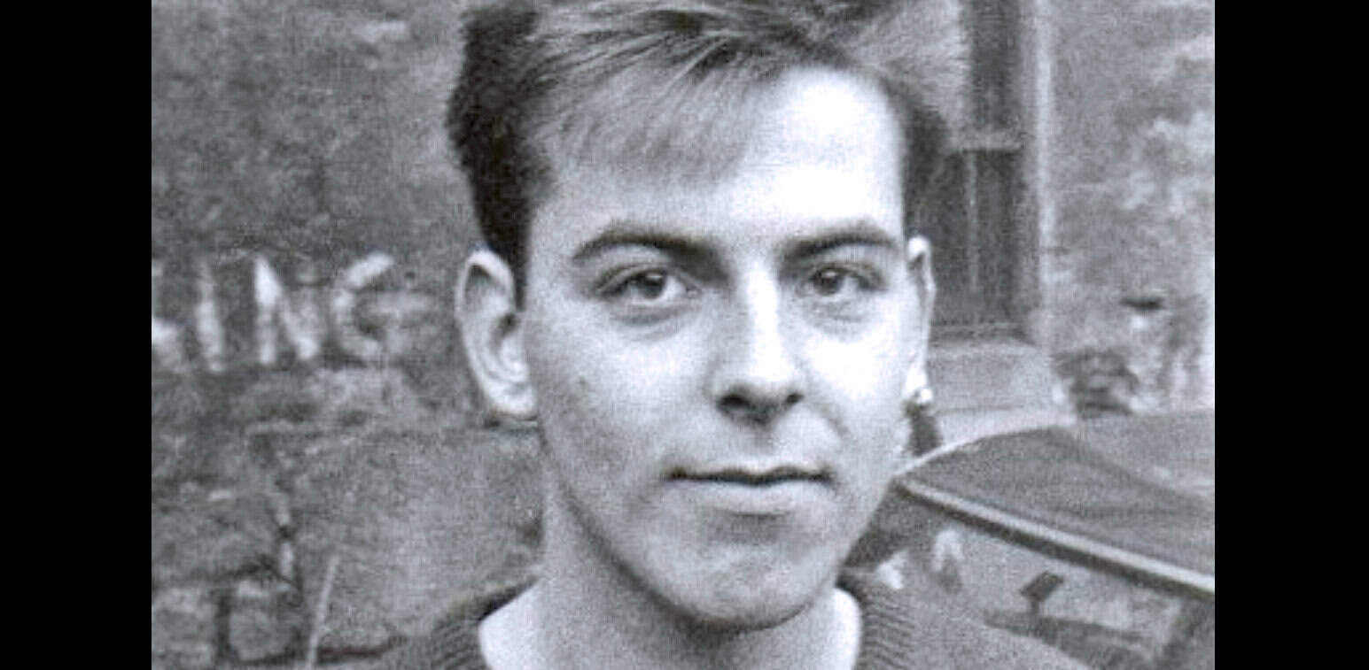 Teenage boy's portrait in black and white with historic background, nostalgic photo, vintage history, youth culture snapshot, mid-20th-century style.