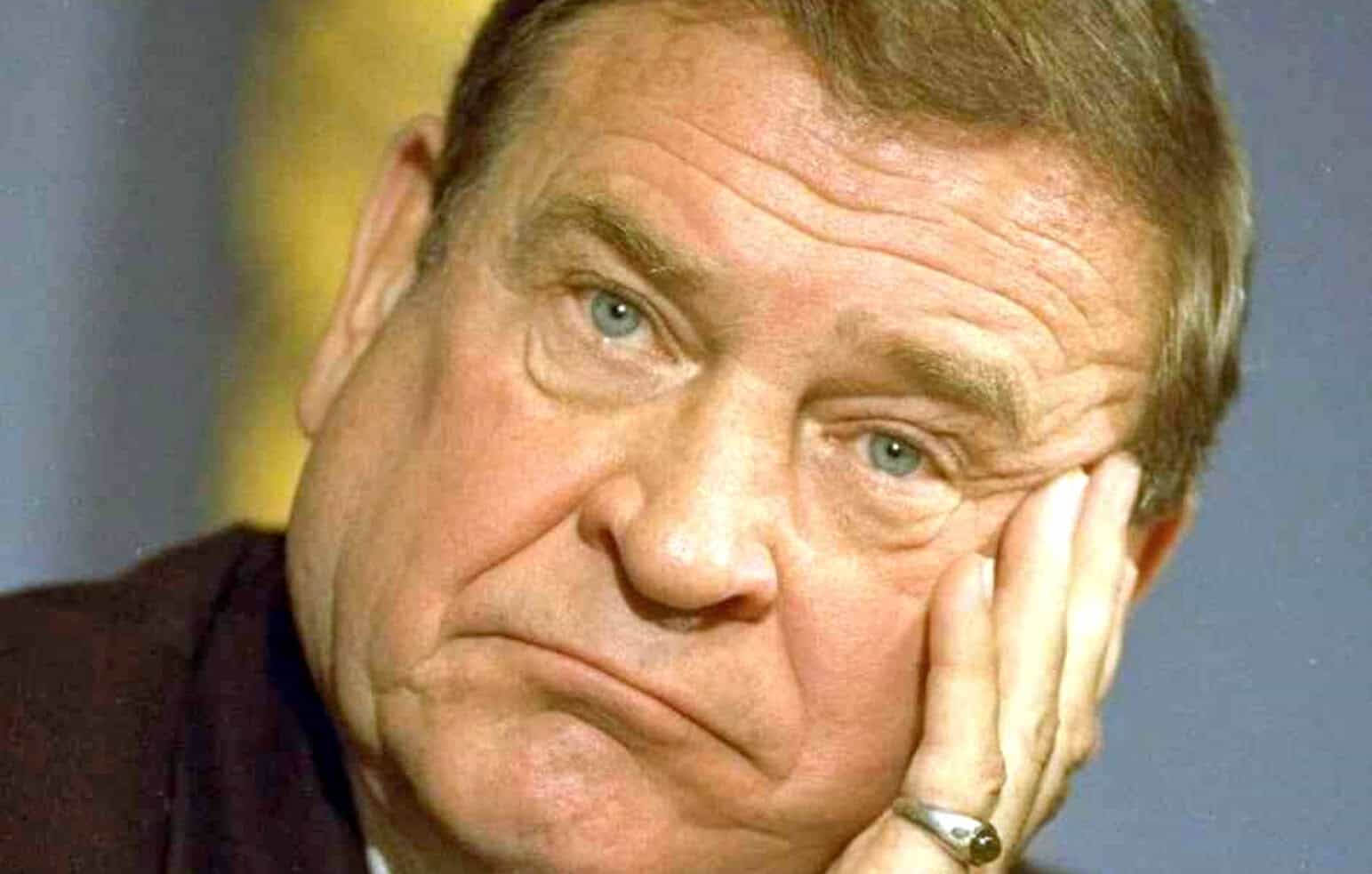 Close-up image of an elderly man with blue eyes, resting his face on his hand, reflecting nostalgia or deep thought, relevant for historical news, music, and sound archive content on Past Daily.