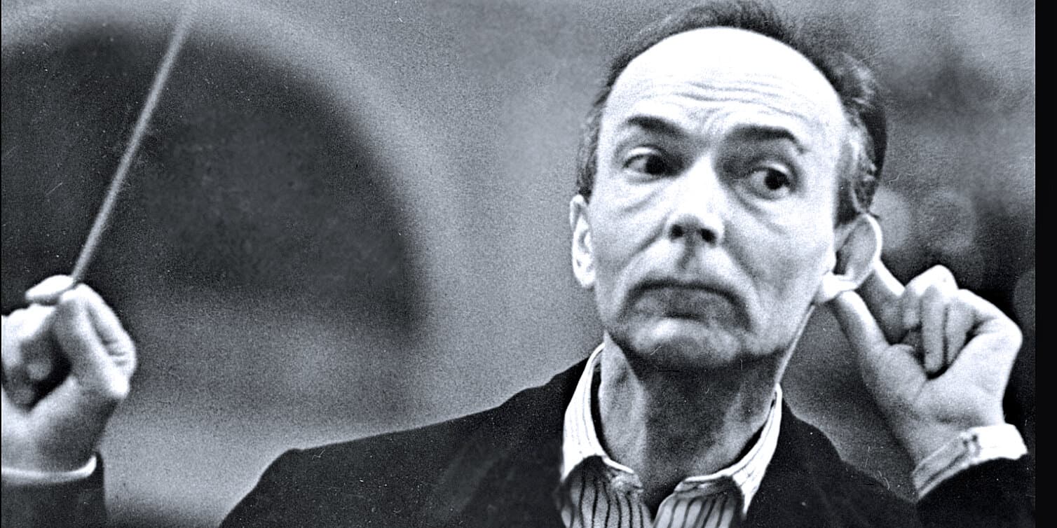 A black and white image of conductor Leonard Bernstein in a moment of intense concentration during a musical performance, emphasizing historic music and classical conductors.