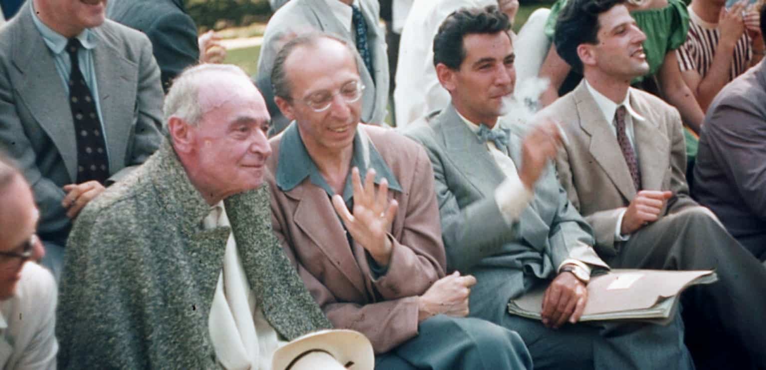 Vintage news and cultural archive featuring a group of men in suits at an outdoor event, capturing mid-20th-century fashion and social history.