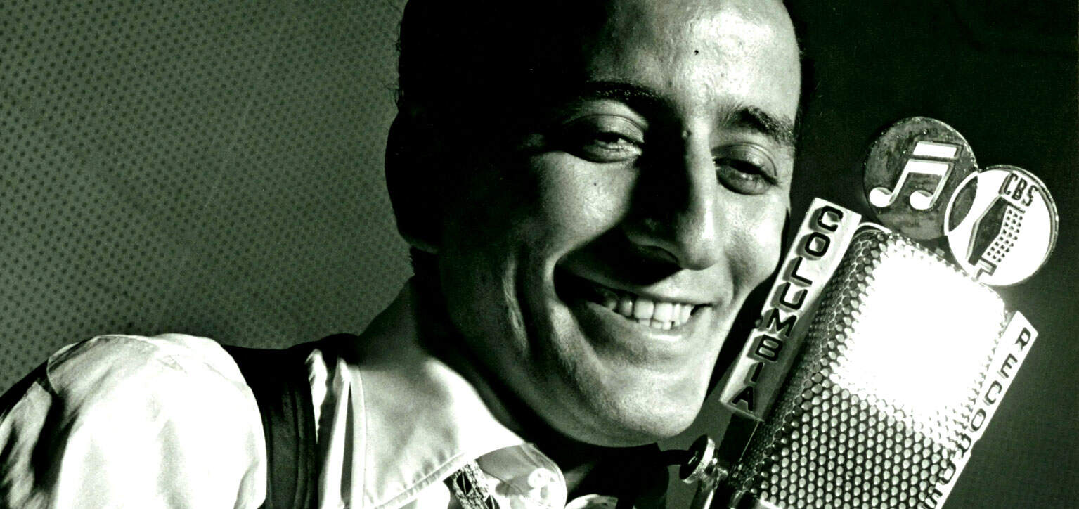 Vintage radio microphone with CBS and music icons, representing classic music and radio broadcasting history at Past Daily archives.