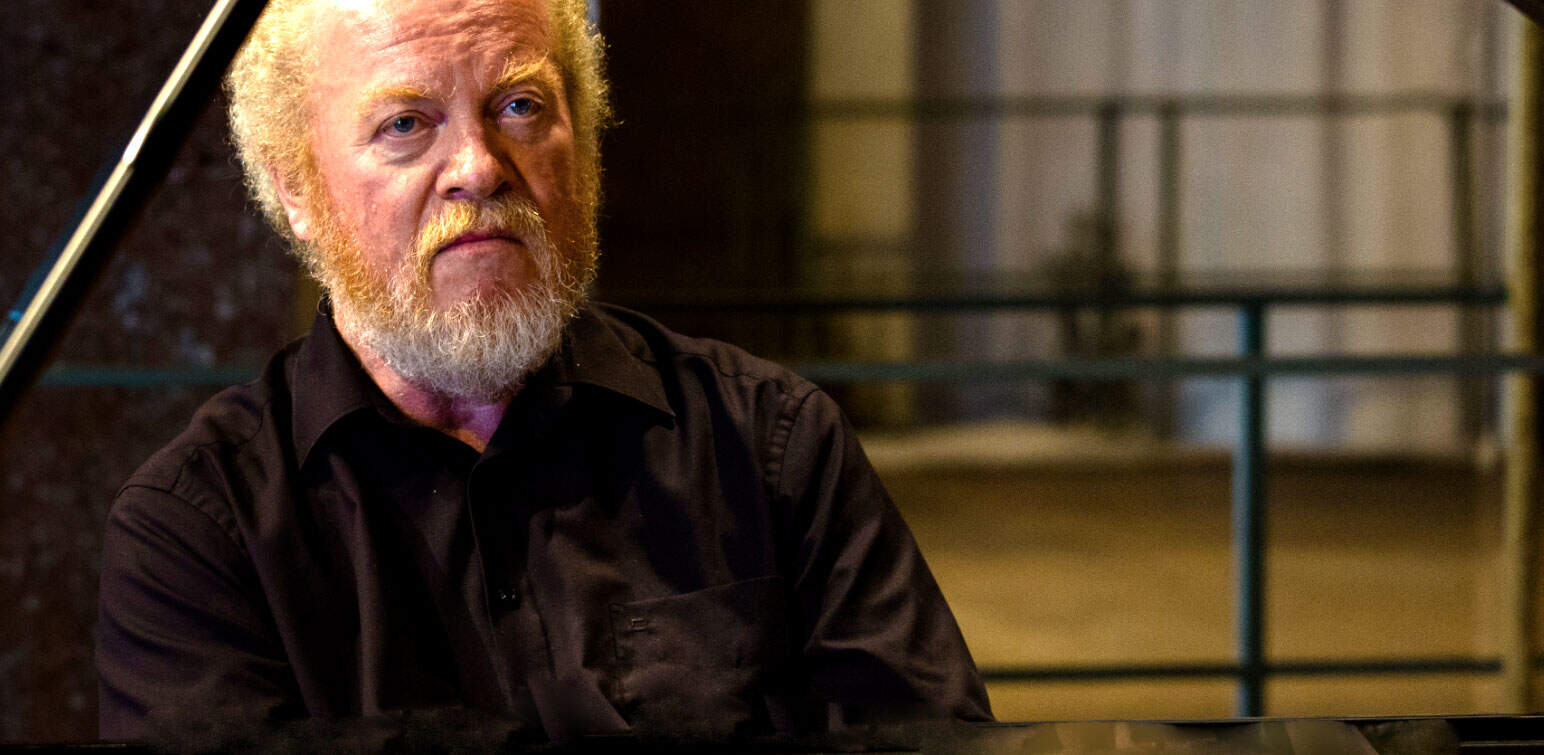 Archive photo of a senior male pianist performing in a historic music venue; highlights the importance of music history and archival sound recordings.