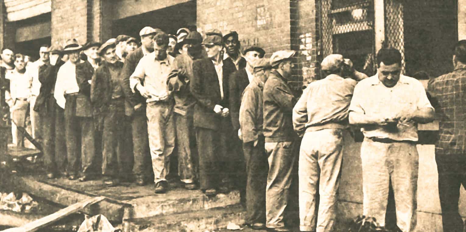 People waiting in line outside a building during a historical event, capturing a moment in history with vintage black-and-white photography.