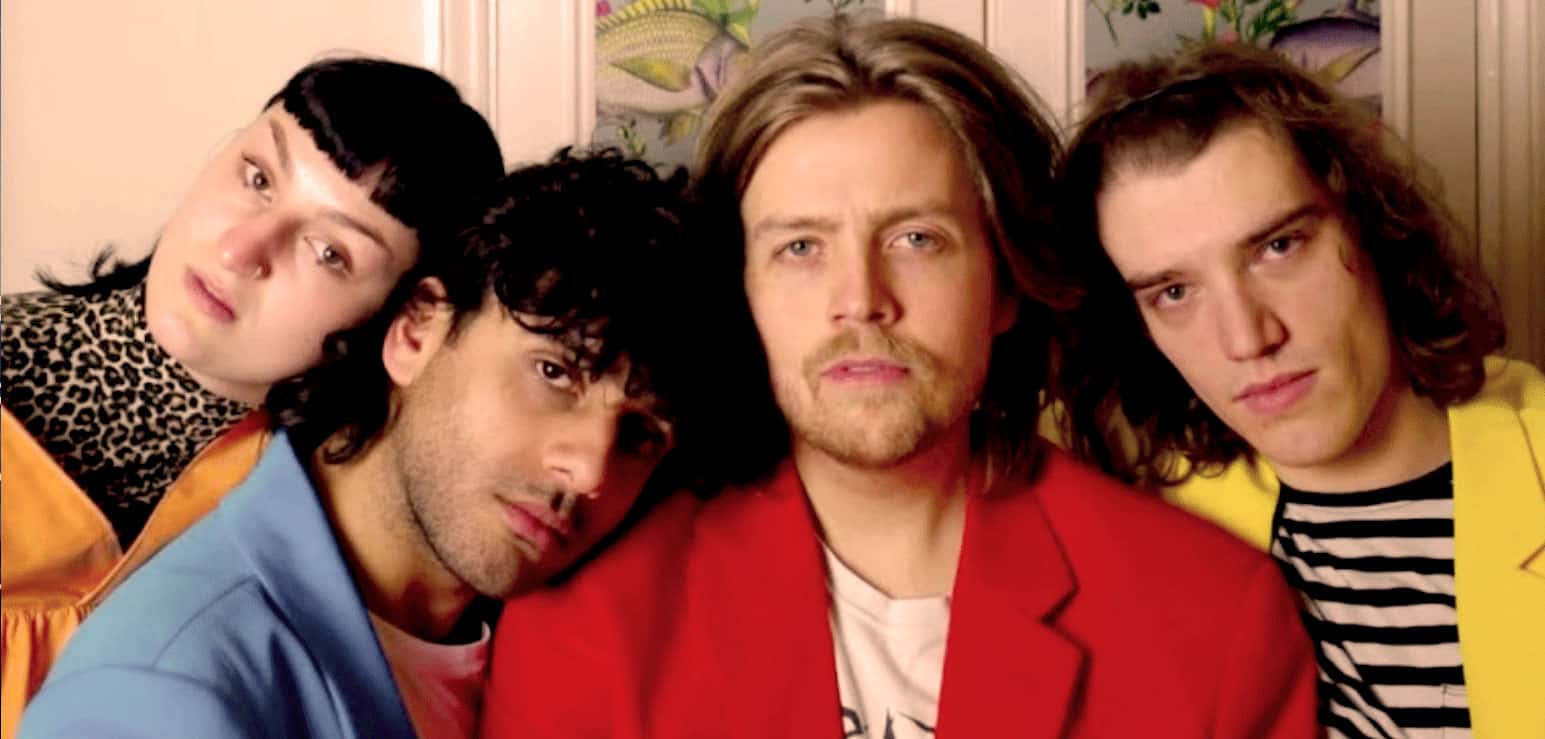 Laughter and music scene from The Bangles' "Walk Like an Egyptian" music video, showcasing vibrant colors and retro fashion styles.