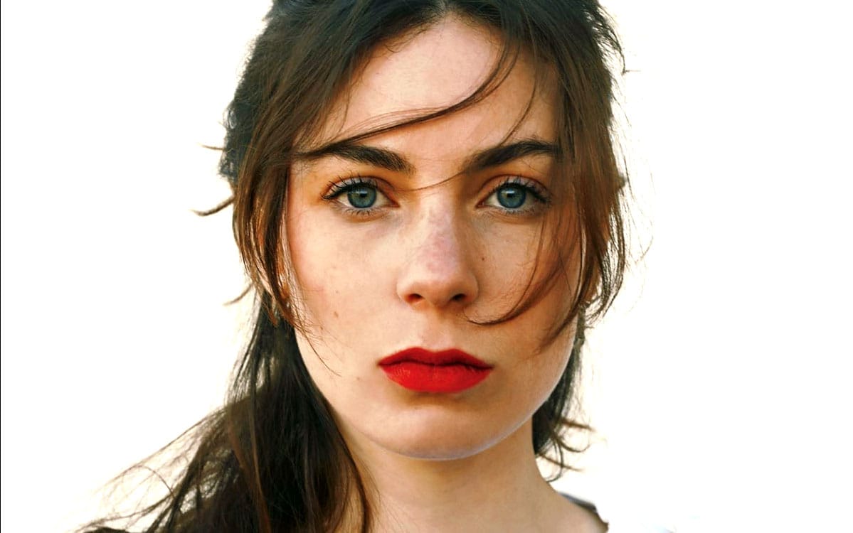 Stunning woman with blue eyes and red lipstick, close-up portrait emphasizing natural beauty and vibrant colors, perfect for showcasing classic beauty and portrait photography.