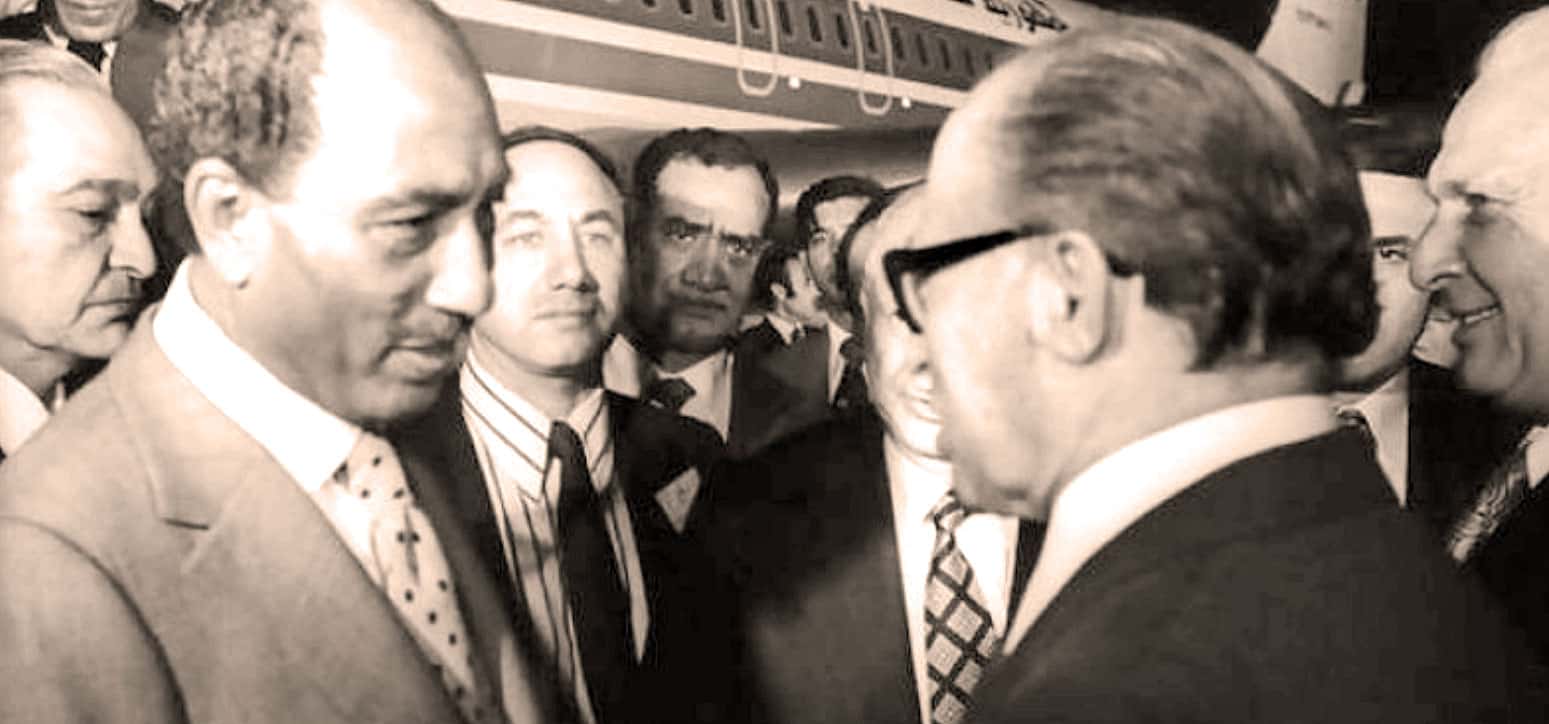 A historic black and white photo of prominent political leaders engaged in discussion at a conference, capturing a significant moment in news, history, and political events.