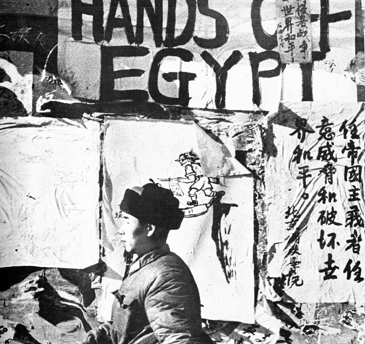A black and white photo capturing a protest scene with a man in profile and handwritten signs advocating for peace and anti-war messages in Chinese and English, highlighting activism and social movements.