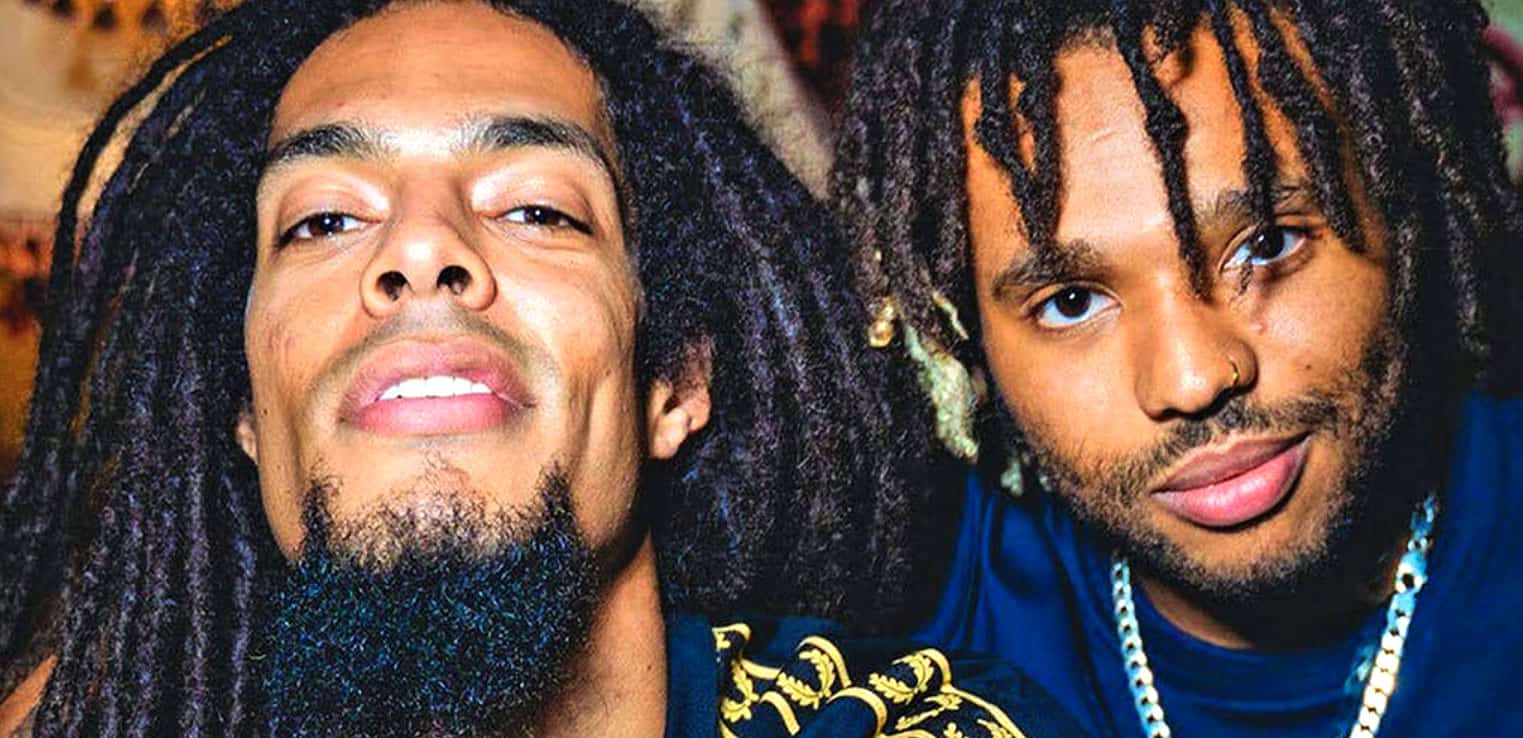 Vibrant portrait of two young men with dreadlocks, close-up face shot, showcasing urban style and cultural expression, ideal for music and history archives related to reggae, hip-hop, or black culture.