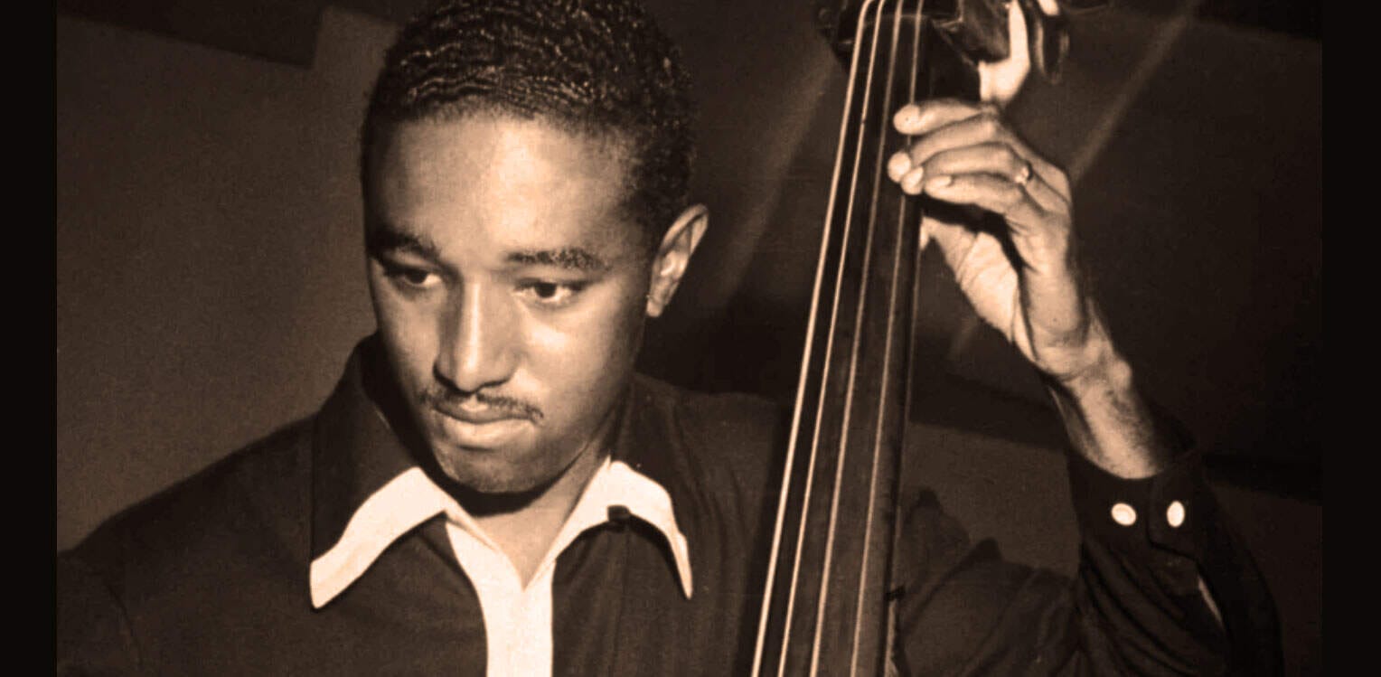 Portrait of a jazz musician playing double bass, emphasizing classic music and history.