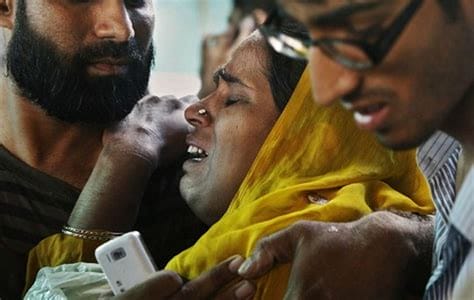 A woman crying while listening to music on her phone, surrounded by supportive friends in a heartfelt moment.