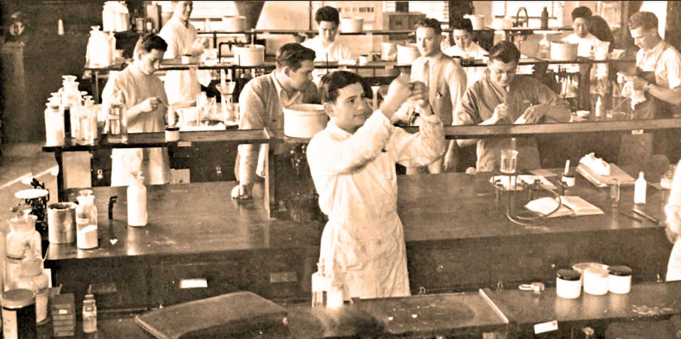 Laboratory students conducting scientific experiments in a classroom or research lab, historical science education, vintage laboratory setting, early 20th-century scientific experiments, educational science laboratory scene.