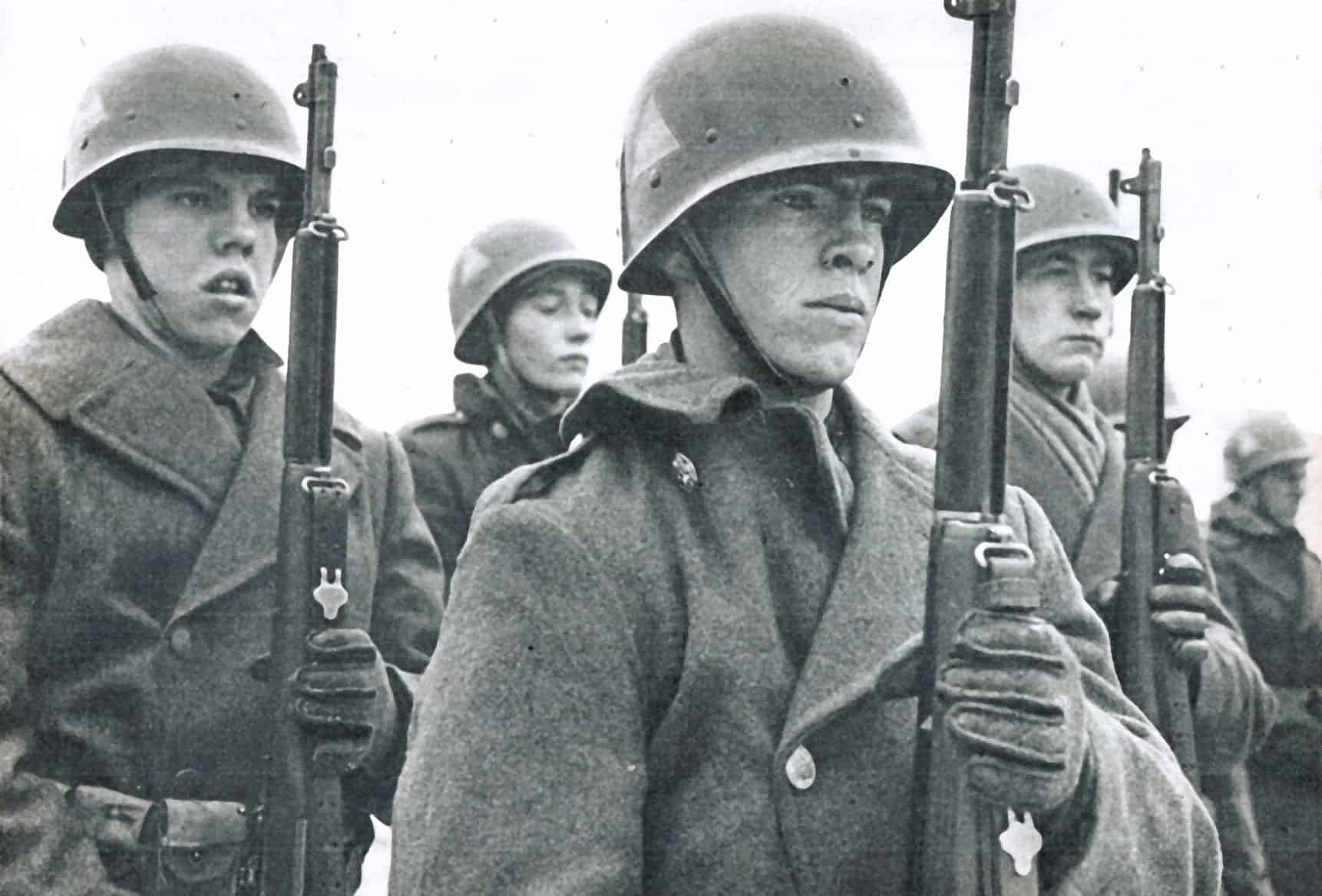 Soldiers in military helmets holding rifles, black and white historical photo, World War II era, military personnel, war history, documentary image.