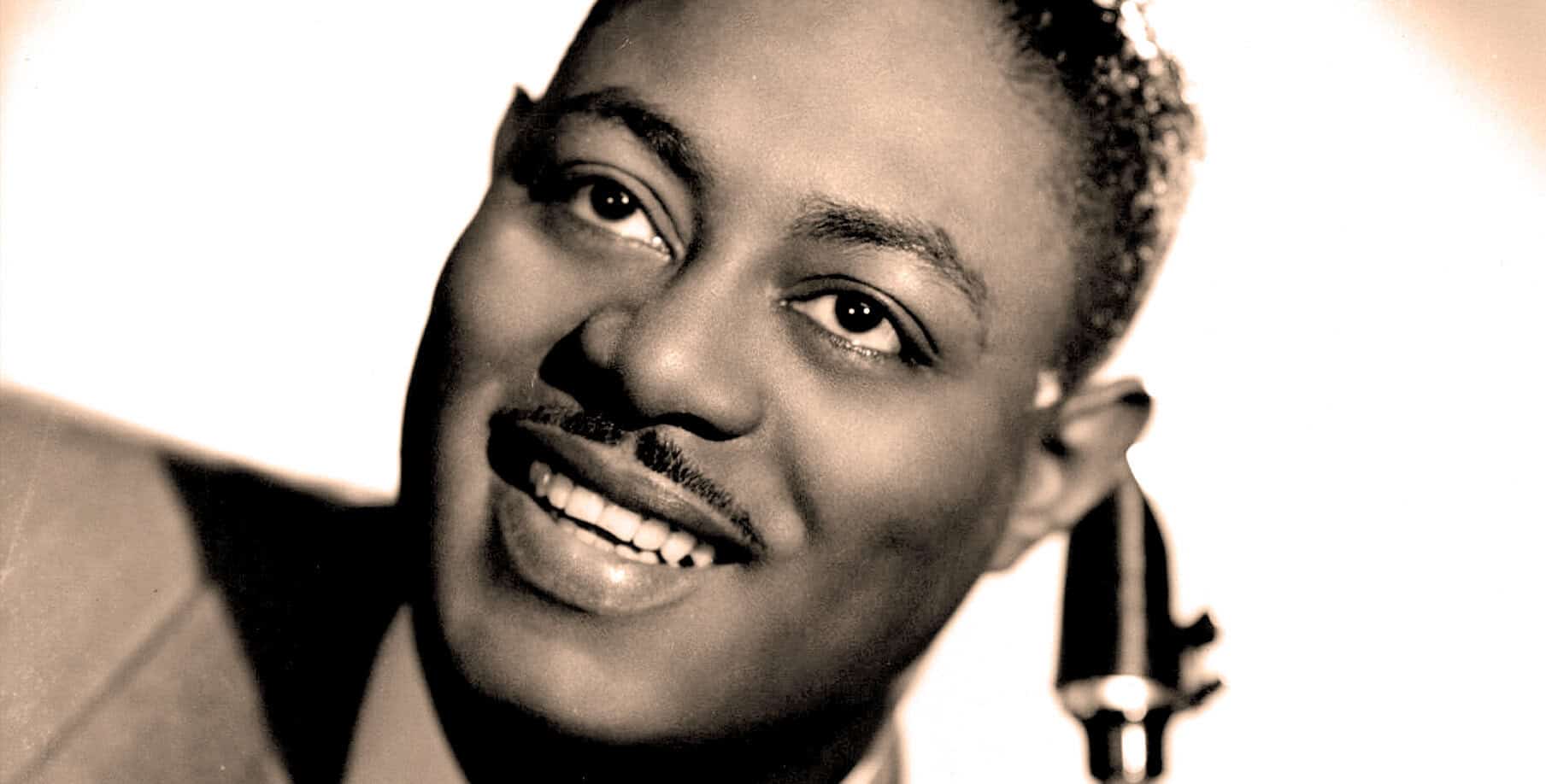 Vintage black and white portrait of a smiling woman, highlighting her joyful facial expression, suitable for a sound archive related to music, history, and news.