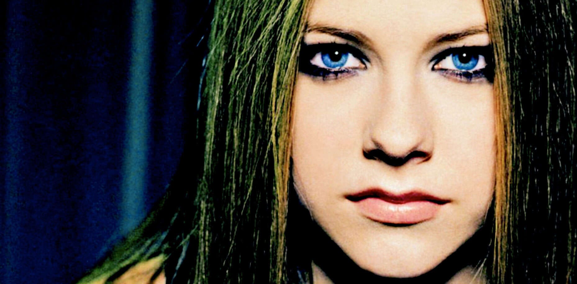 Blue-eyed woman with long straight hair and bold makeup, portrait of female model with striking eyes and flawless skin, fashion and beauty photography, elegant and modern style, high-resolution image for magazine or cosmetic ad.