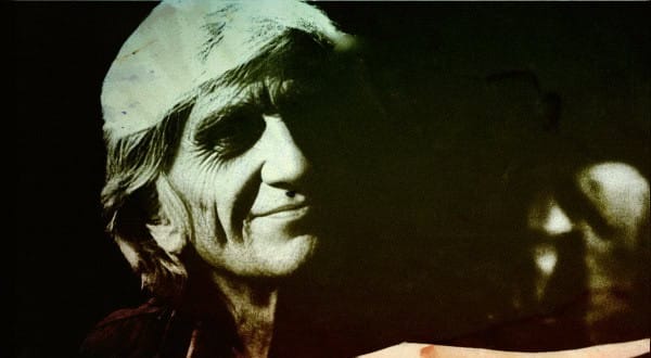 Vintage black and white photo of a smiling woman wearing a hat, representing historical news and music archives.